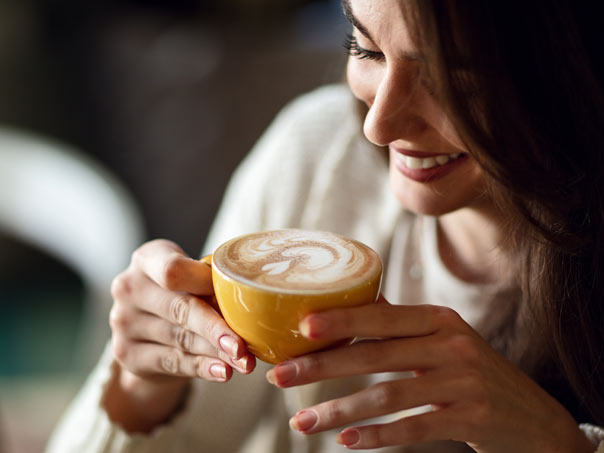 Woman Smiling and drinking coffee