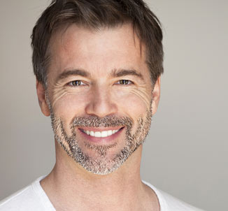 Middle aged man wearing white shirt smiling at camera