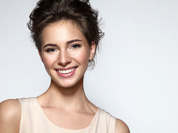 Woman Smiling at camera with hair tied back